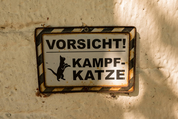 Assine com o texto em alemão traduzido Cuidado Combat Cat - Foto, Imagem
