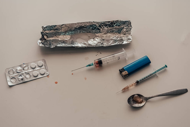 Een spuit met heroïne (amfetamine) op tafel. verslaving - Foto, afbeelding