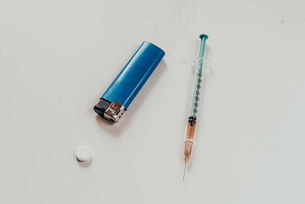 Egy fecskendőt heroinnal (amfetaminnal) az asztalon. függőség - Fotó, kép