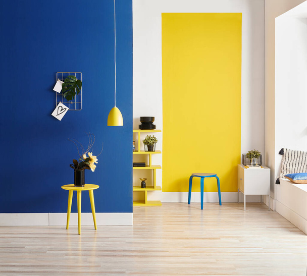 sfondo della parete gialla e blu, stile interno, legno rotondo, cornice e lampada. - Foto, immagini