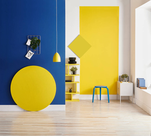 Žluté a modré pozadí stěny, vnitřní styl, kulaté dřevo, rám a lampa. - Fotografie, Obrázek