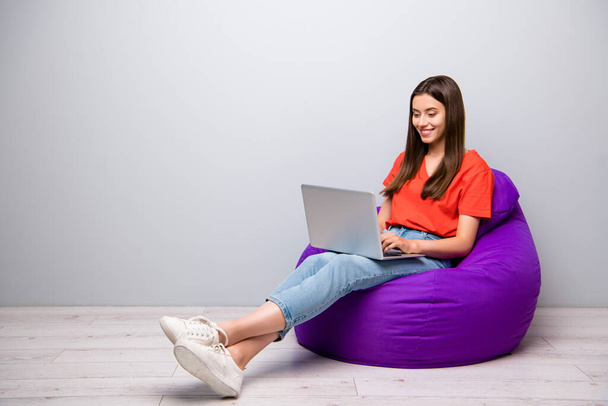 Portrait of her she nice attractive lovely pretty cheerful cheery straight-haired girl sitting in bag chair using digital laptop creating report presentation light grey pastel color wall room - Fotoğraf, Görsel