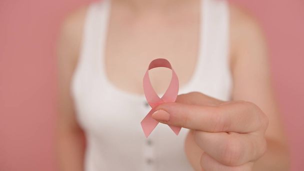 ПАРК жовтень, стрічка обізнаності про рак в руці молодої невизначеної жінки
 - Фото, зображення