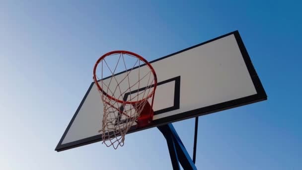 Rode basketbal hoepel op blauwe lucht achtergrond - Video