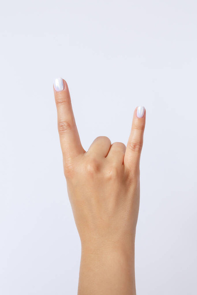 Gesture and sign, hand on a white background. Hand showing rock - Foto, imagen