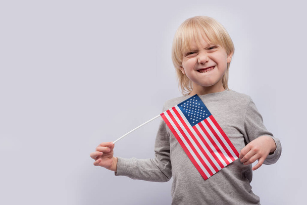 Αστείο αγόρι με αμερικανική σημαία. μελέτη της αγγλικής γλώσσας και της εκπαίδευσης στις ΗΠΑ έννοια. - Φωτογραφία, εικόνα