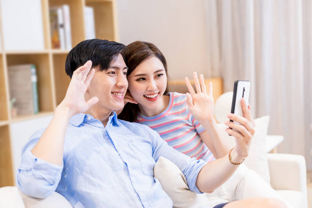 asian young couple have video chat by smart phone at home happily - Fotó, kép