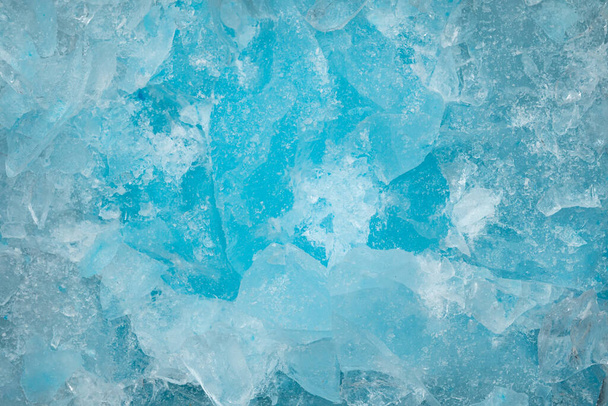 砕いた青い氷のガラスの破片が背景のテクスチャをクラックする。閉じ込められた凍った水 - 写真・画像