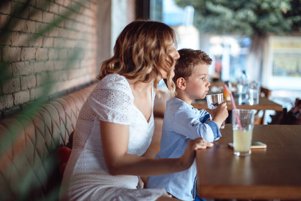 Mom sitting with her son in the cafe. Mother parent relationship - Фото, зображення