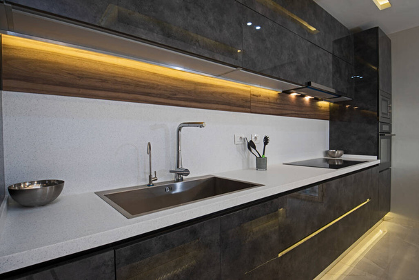 Interior design decor showing modern kitchen with cupboards and sink in luxury apartment showroom - Foto, afbeelding