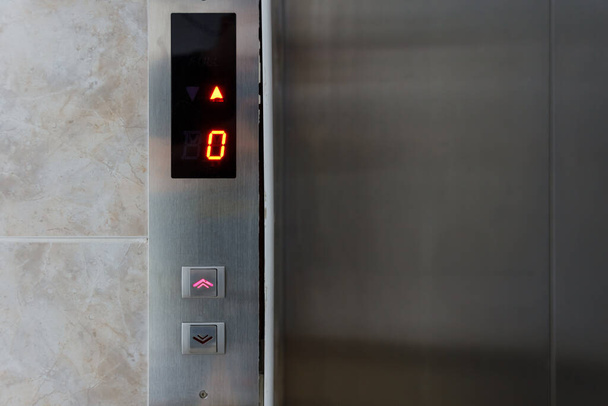 Panel elevador metálico con botón y pantalla led. Interior y primer plano de botones metálicos en ascensor - Foto, imagen
