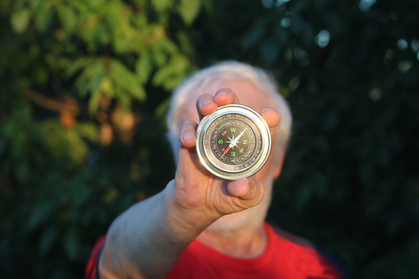 Круглый классический компас в руке человека - Фото, изображение