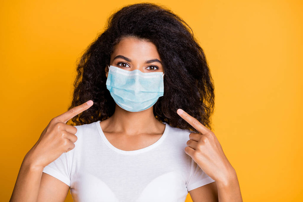 Close-up portrait of her she nice attractive healthy wavy-haired girl demonstrating wearing safety gauze mask mers cov pathogen influenza preventive measures isolated vivid yellow color background - Photo, Image