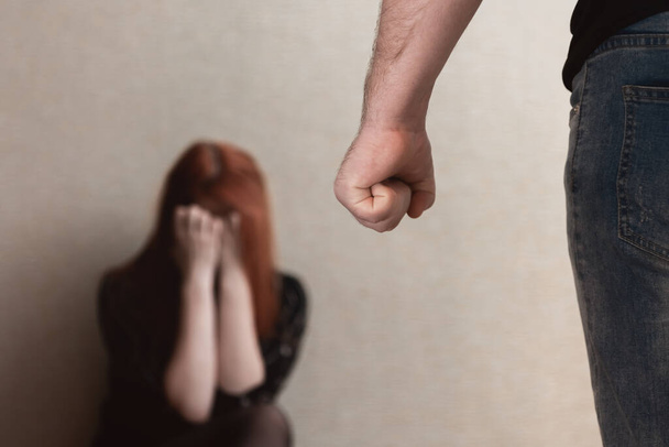 Missbrauch häuslicher Gewalt. Eine Frau aus Angst vor häuslicher Gewalt. Ein Mann schlägt seine Frau. Soziale Frage - Foto, Bild