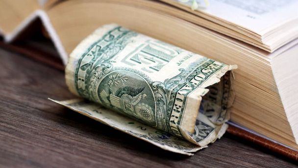Old books with one dollar. Concept for buyng or selling books. - Photo, Image