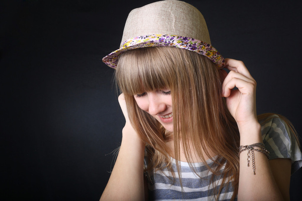 smiling happy teenage girl laughs keep her hat indoors - Foto, Imagem