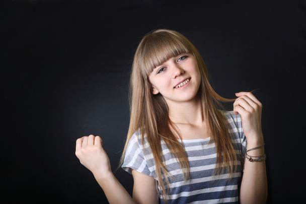 uśmiechający się ładny nastolatek młode dziewczyny dotknąć blond włosy - Zdjęcie, obraz