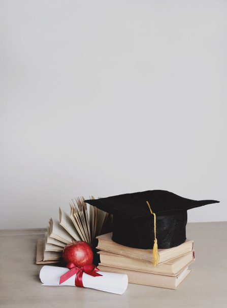 Graduierung. Quadratischer akademischer Hut mit Büchern - Foto, Bild