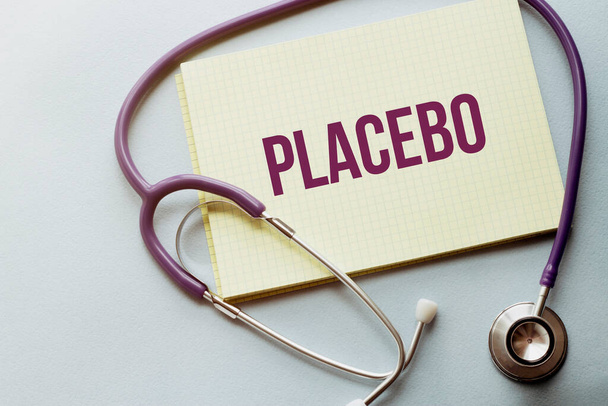 On a purple background a stethoscope with yellow list with text PLACEBO - Photo, image