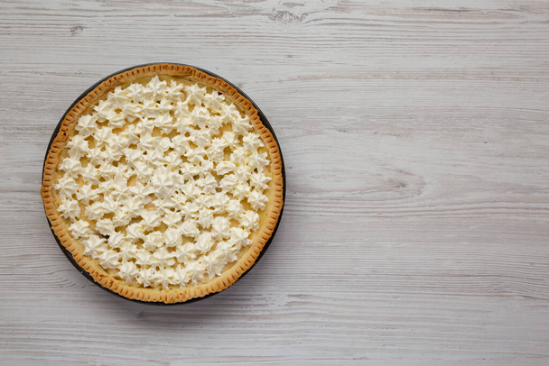 Zelfgemaakte Lekkere Banaan Crème Pie op een witte houten achtergrond, bovenaanzicht. Plat gelegen, boven, van boven. Ruimte voor tekst. - Foto, afbeelding