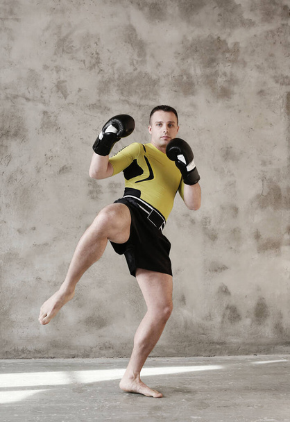 Guapo kickboxer sobre un fondo gris - Foto, Imagen