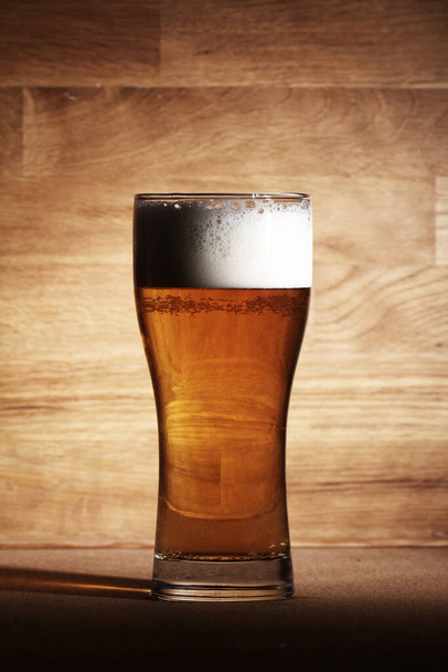 Glas kaltes Bier über der Holzoberfläche - Foto, Bild
