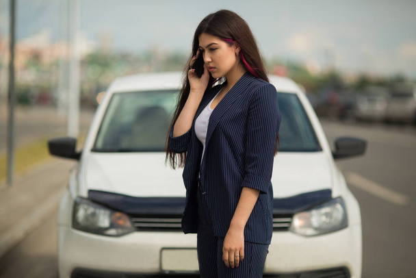 beautiful young woman with phone near car - Фото, изображение