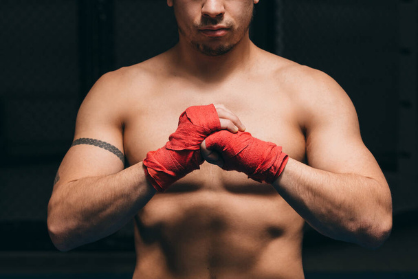 Male boxer getting concentrated, puts fists on foreground, ready to big fight - 写真・画像