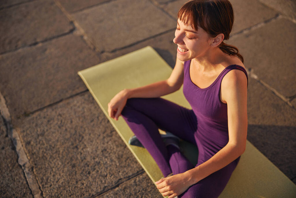 Close up colpo giovane donna che sta sorridendo e iniziare lo yoga mattina - Foto, immagini