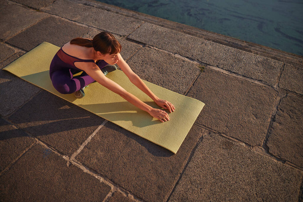 Shot from above of young woman who is practicing the morning yoga outdoor - Photo, Image