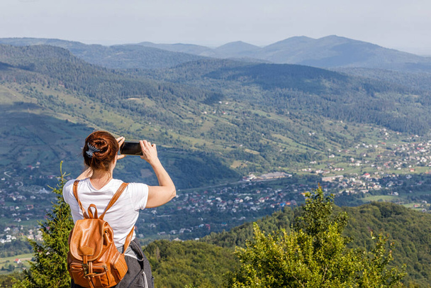 Nainen turisti valokuvia puhelimessa näkymä vuoristoinen alue. - Valokuva, kuva
