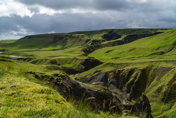 paysage avec herbe verte et nuages et une cascade lointaine - Photo, image