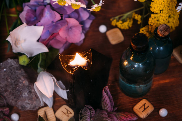 Magic potion bottle. Witchcraft halloween concept with potions, herbs and occult equipment. Magical still life with copy space on a dark background. - Photo, image