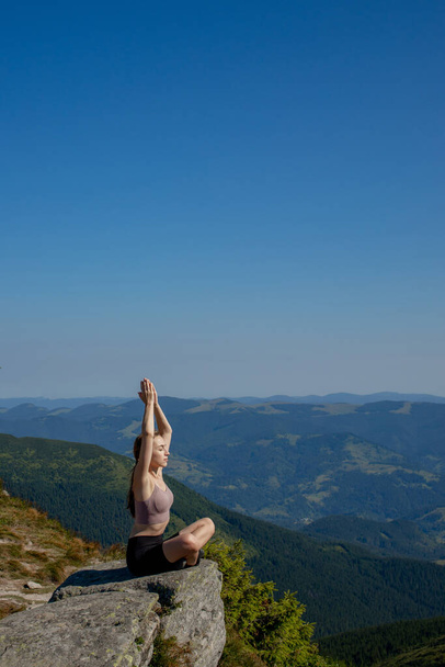 Yoga, Meditation. Woman balanced, practicing meditation and zen energy yoga in mountains. Girl doing fitness exercise sport outdoors in morning. Healthy lifestyle concept - Photo, image