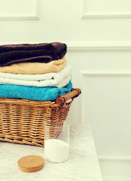 Πλυντήριο ρούχων. Μαύρο καλάθι με καθαρές πετσέτες - Φωτογραφία, εικόνα