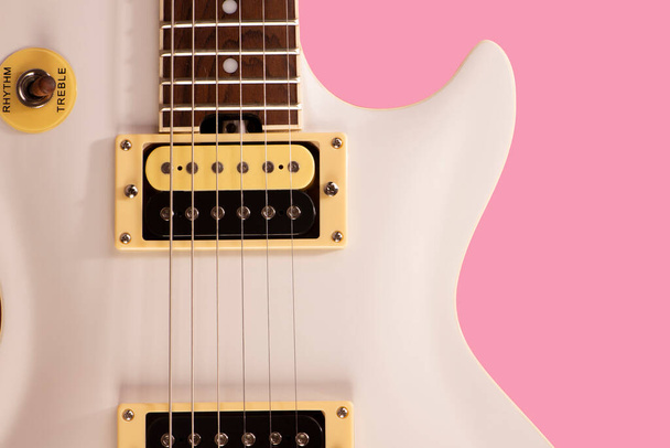 parte anteriore del corpo di una chitarra elettrica bianca su sfondo rosa. - Foto, immagini