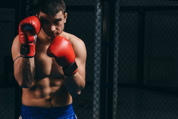 Athletic male boxer training at boxing studio, standing in defensive stance. - Φωτογραφία, εικόνα