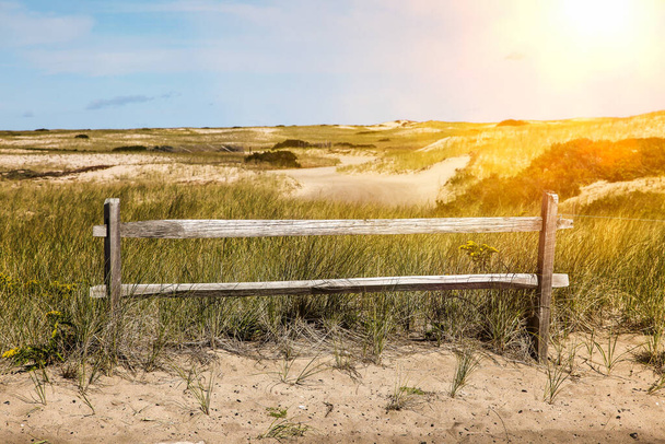Recinzione con vista dune di sabbia e cielo blu con sole - Foto, immagini