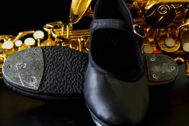 close up on tap shoe, defocused saxophone background, short depth of field. - Photo, Image