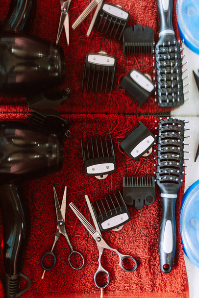 Vue de dessus des ciseaux, sèche-cheveux, tondeuse, peigne et autres accessoires de coiffeur - Photo, image