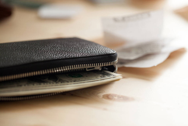 Skórzany portfel z gotówką na drewnianym stole z czekami - Zdjęcie, obraz