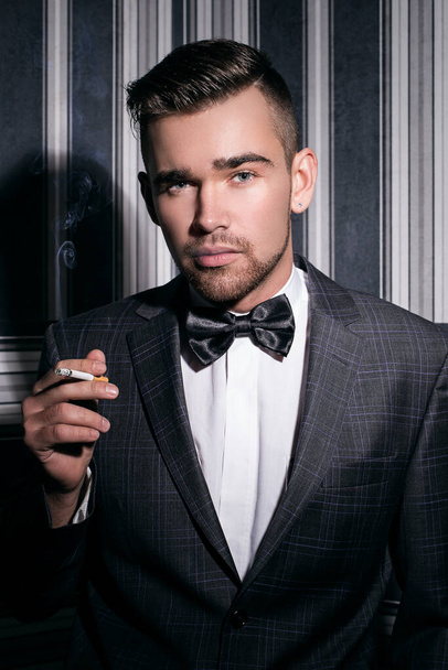 Retrato de un hombre guapo con traje y cigarrillo - Foto, Imagen