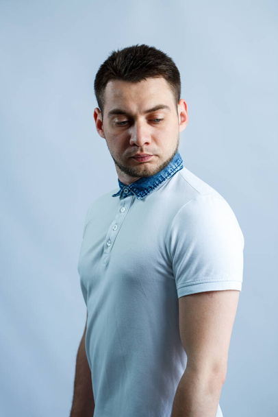 Portrait of a man in a white polo on a white background. Male image for every day. Stylish guy - Zdjęcie, obraz