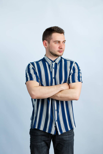 Portrait of a young man in a striped shirt on a white background. Stylish guy dressed in casual style. Male image for every day - Zdjęcie, obraz