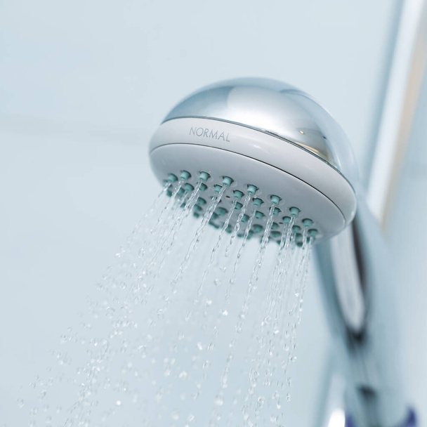 Srebrny prysznic z płynącą wodą w łazience - Zdjęcie, obraz