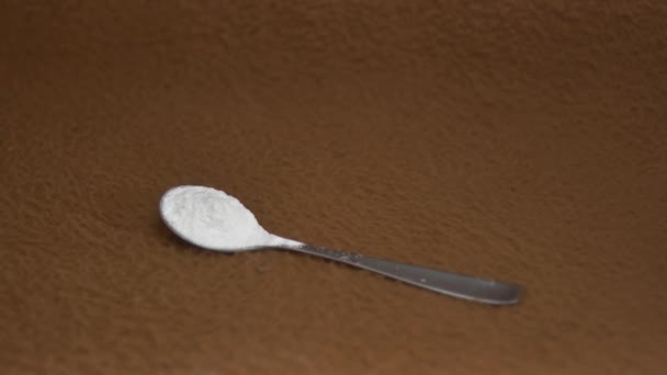 Una cucharadita llena de levadura seca sobre un fondo marrón - Metraje, vídeo