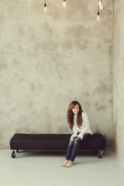 Beautiful woman on a tufted bench - Valokuva, kuva