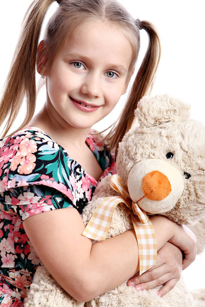 Cute girl with her teddy bear over white background - Фото, изображение