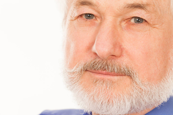 Hombre mayor guapo con barba gris sobre fondo blanco - Foto, Imagen