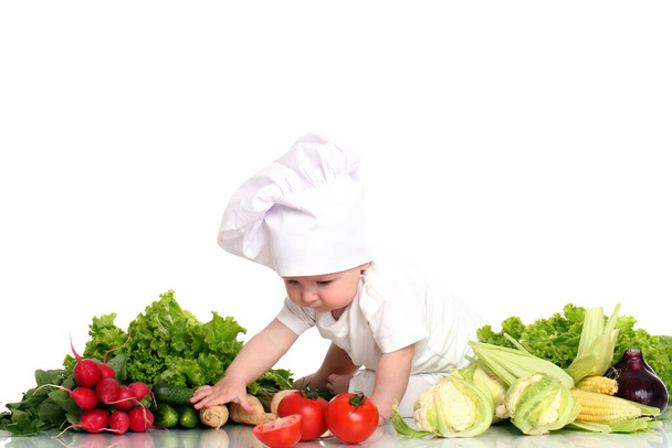 Cute baby chef with different vegetables over white background - Fotografie, Obrázek